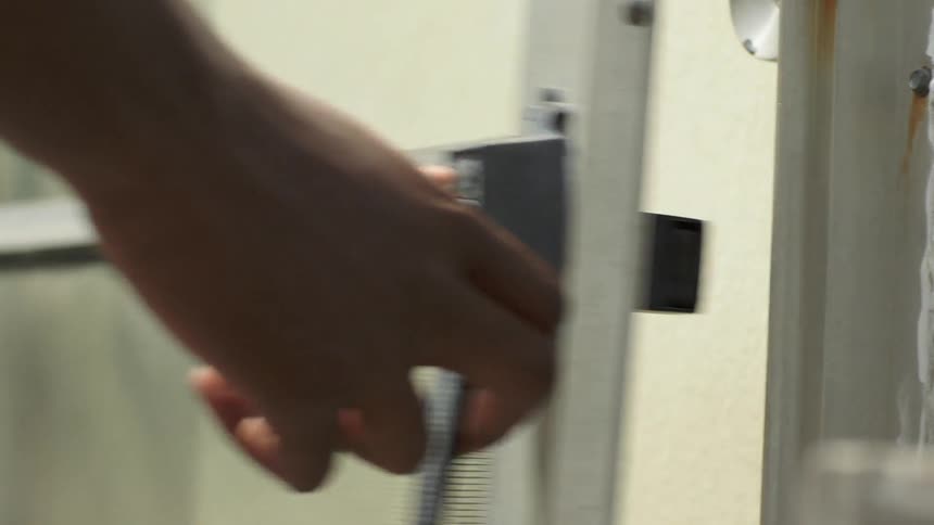 A person opens a broken screen door