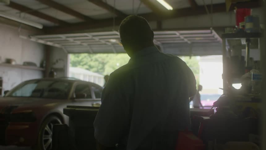 A man stands in a large garage