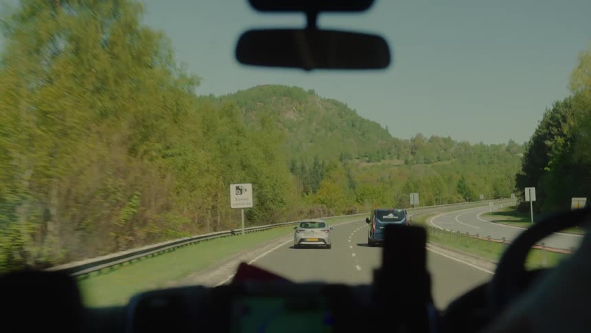 Cars driving down a road on a sunny day