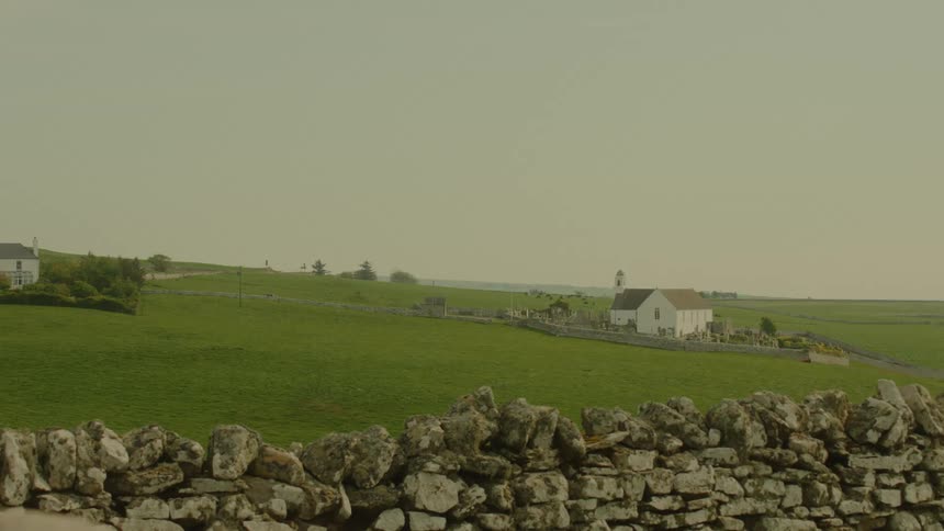 A rock wall runs along the property boundary of a farm