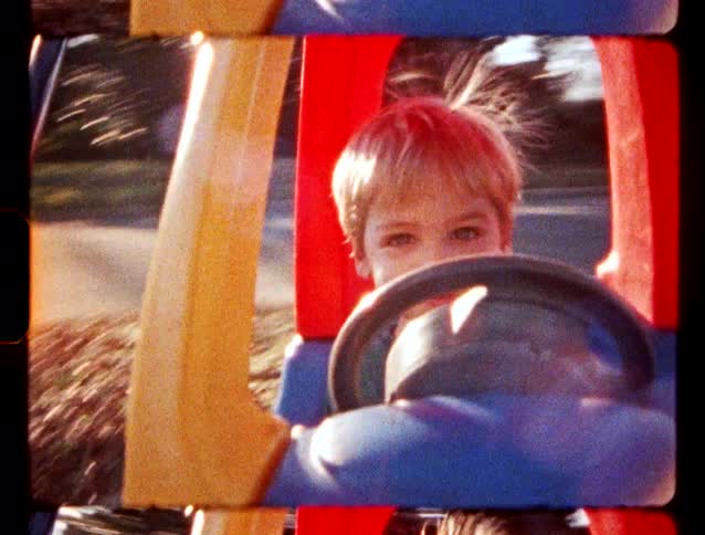 Boy inside a toy car holding the steering wheel