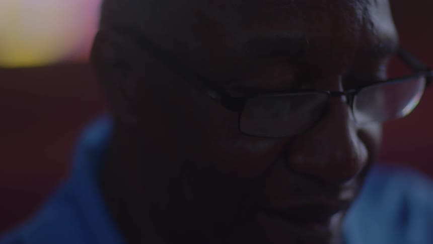 Spectacled man looking down at something