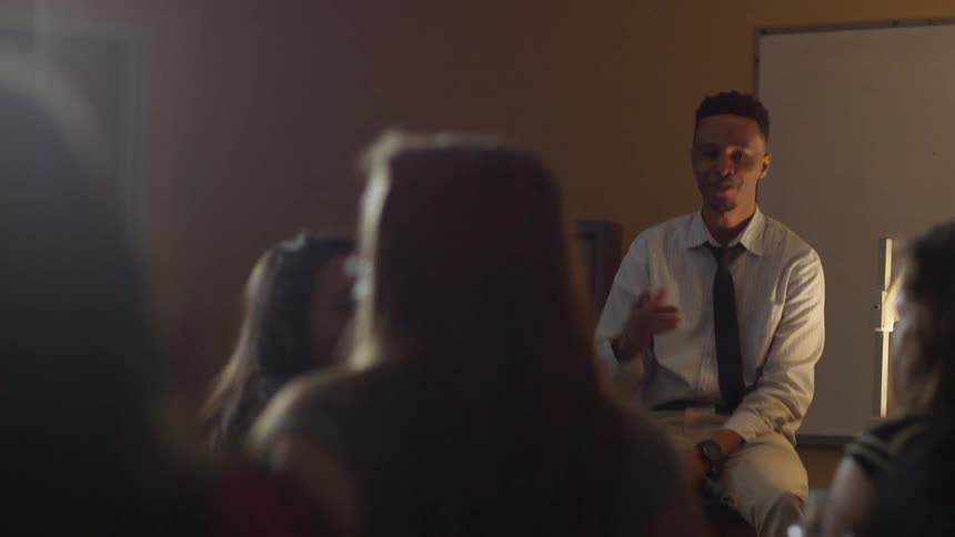 A teacher is taking questions from a class full of students
