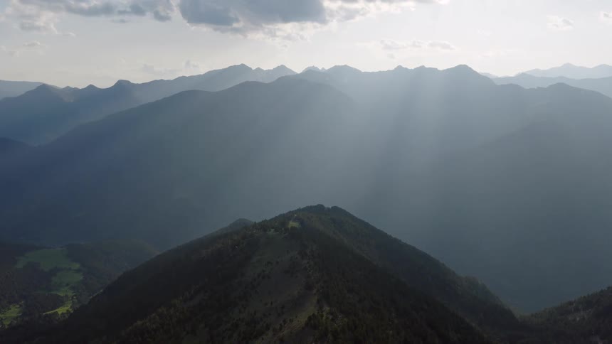 Mountain ridges lit by sun rays through clouds