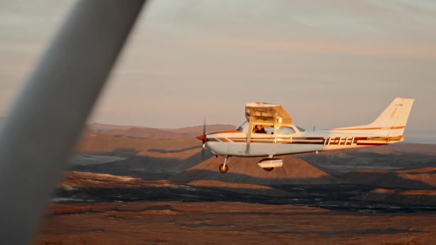A plane flying over a desert landscape