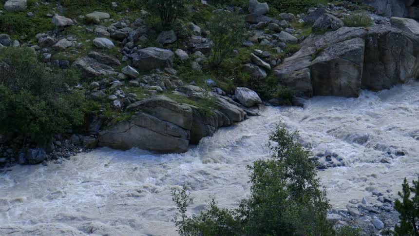 River rushing past large rocks in wilderness