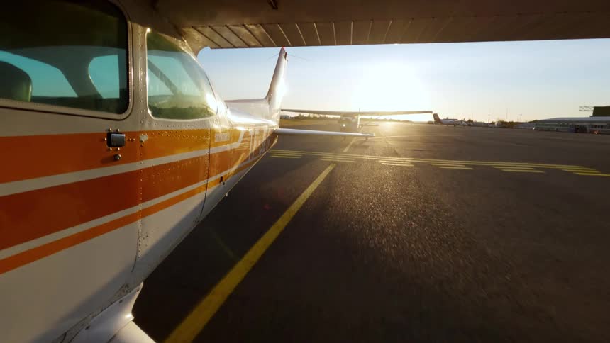 Singleengine airplane accelerates on the runway during takeoff at sunset