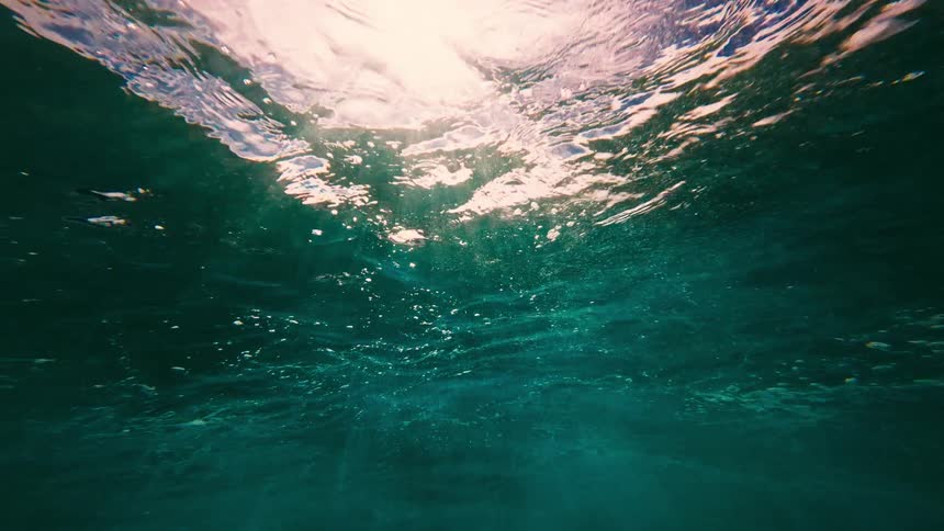 Sunlight passes through the rippling surface of blue water