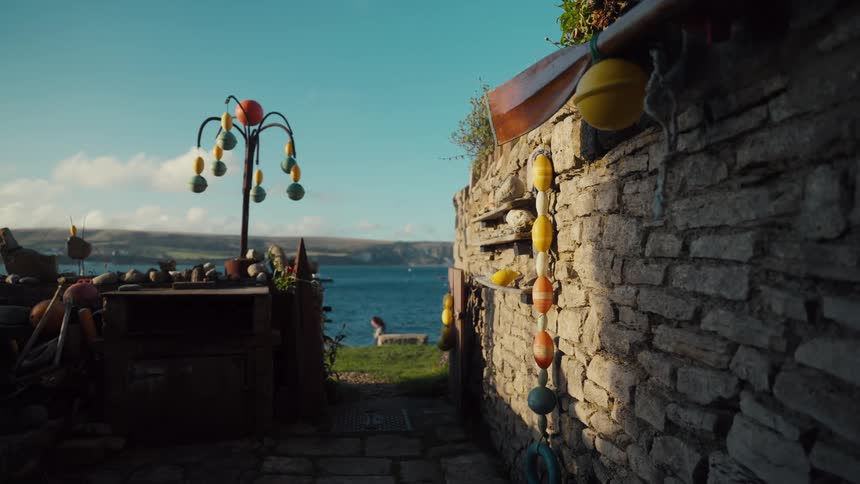 Stone passage by the seaside with colorful buoys hanging and ocean view