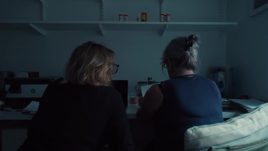 Two women using a computer in a room