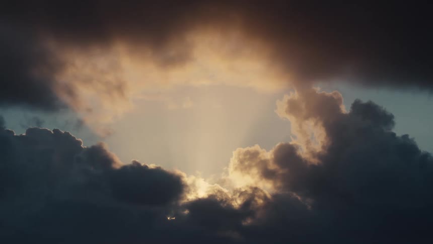 Sunlight highlights parts of the clouds while the rest of the clouds remain dark