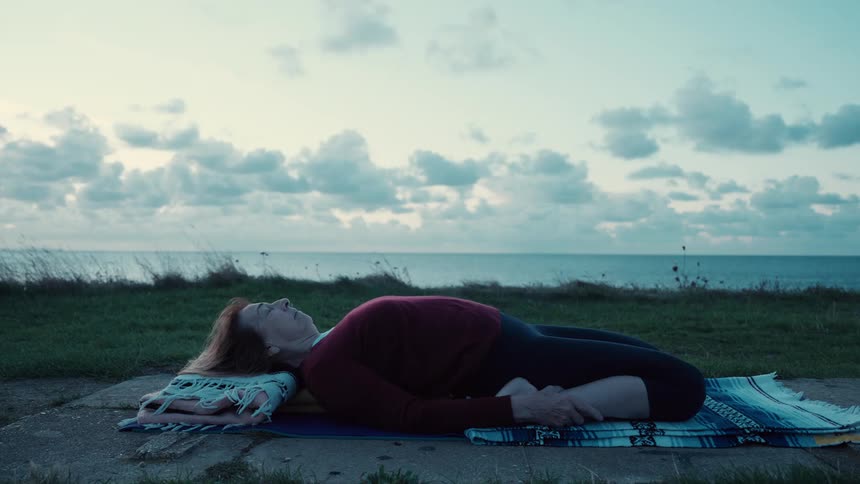 The woman is resting by the shore