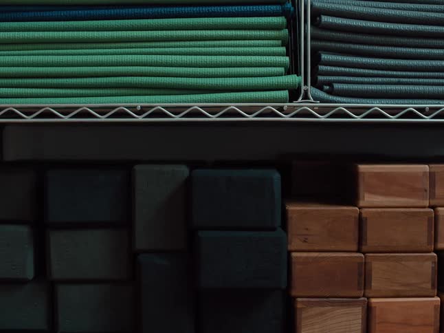 The person stacks boxes on the shelf