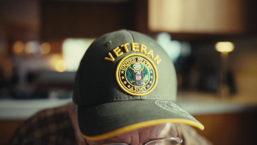 Green cap with an embroidered emblem in focus indoors