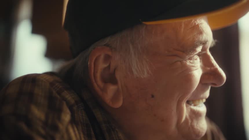 Smiling elderly man taking off his glasses