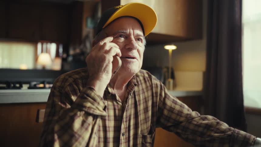 The man answers his phone while at home