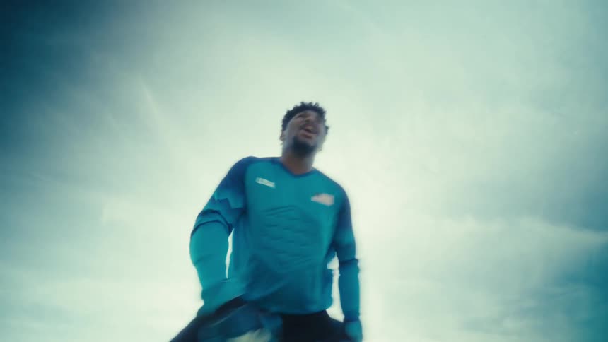 Goalkeeper and player jumping during outdoor warmup