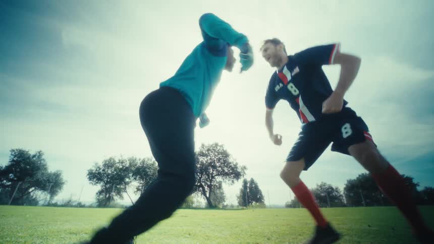 Two men playing soccer and dancing around
