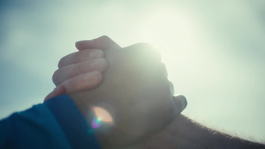 Two men shake hands on a sunny day