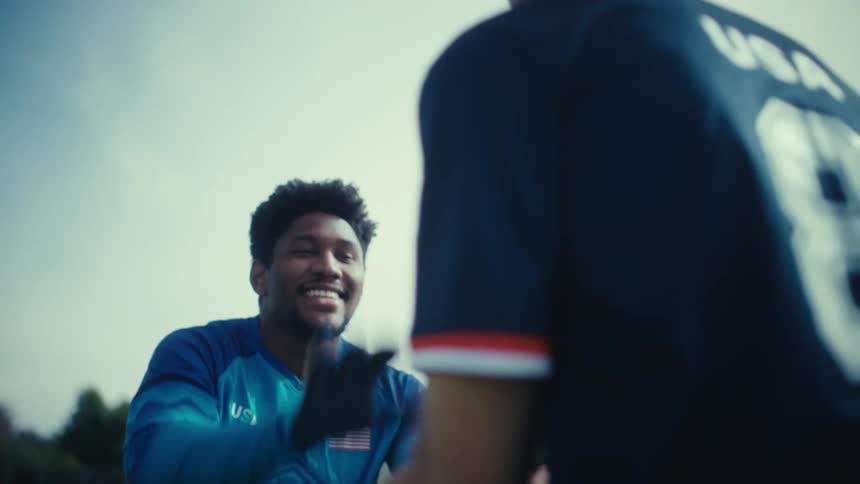 Two men high five on a cloudy day