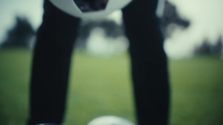 The man picks up the soccer ball