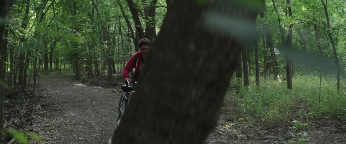 Man walks his bike through the woods