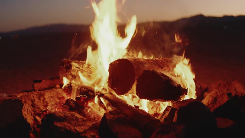 Bonfire lit in a natural setting at dusk