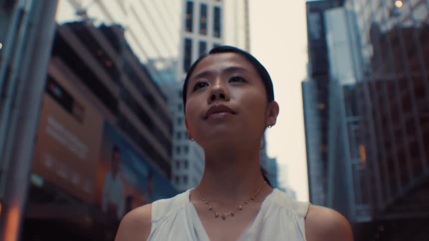 The woman is walking through the city on a cloudy day