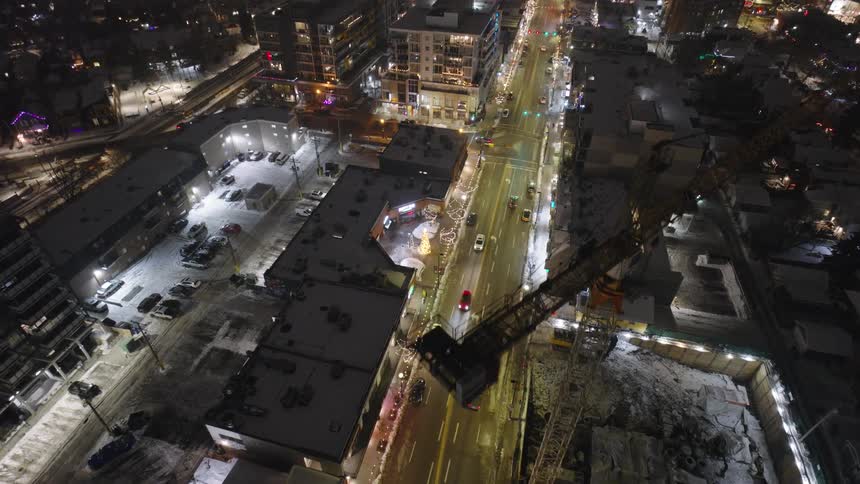 Aerial view of city at night with illuminated buildings and traffic on the avenues