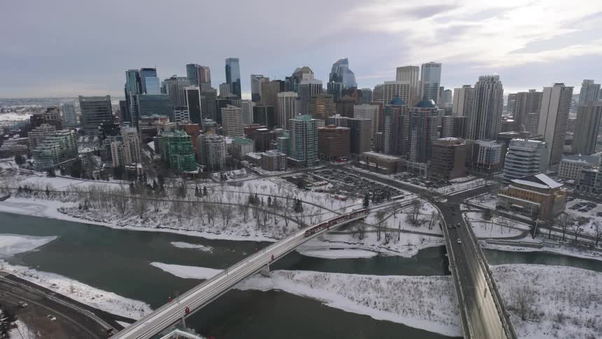 Aerial of cars and trains driving across two bridges in a metropolis