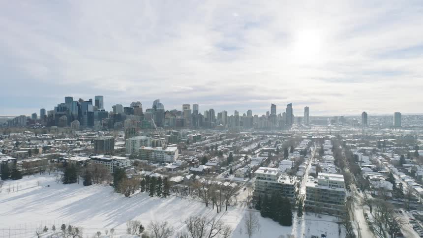 Aerial view of an urban area with highrise buildings in the background and snowcovered houses in the foreground