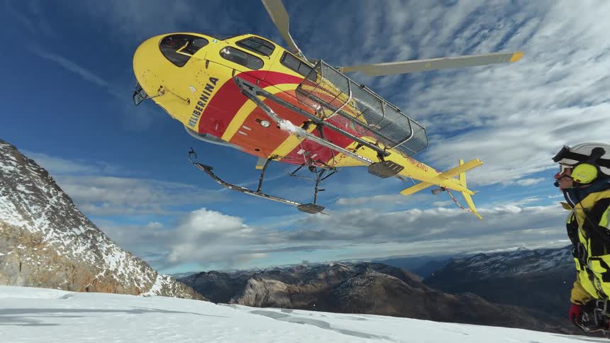A helicopter lifting off from a mountain