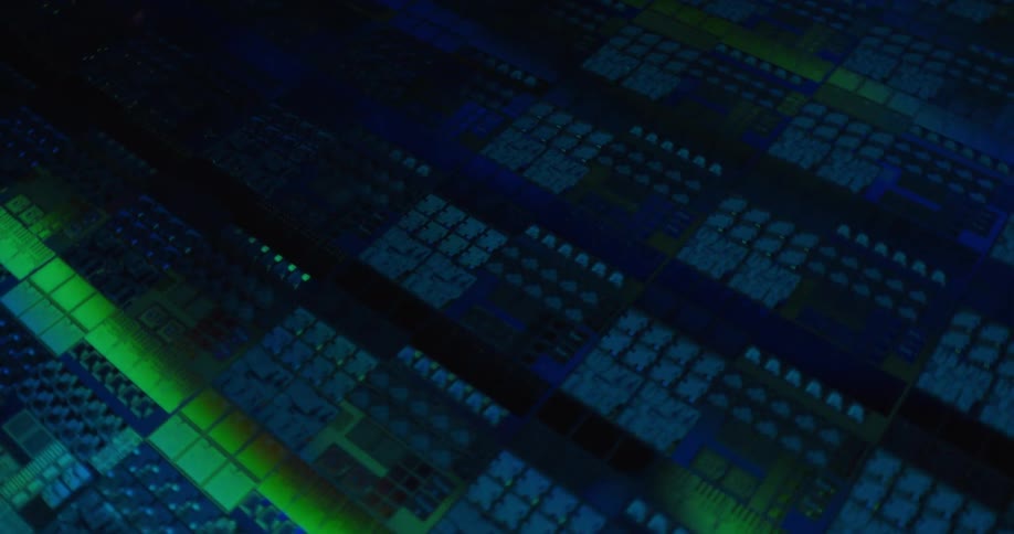 Microchip pattern with circuits and geometric blocks illuminated in blue and green