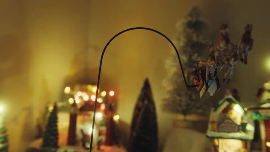 Pole supports figurines of santa and his sleigh flying through the air as part of elaborate christmas decorations