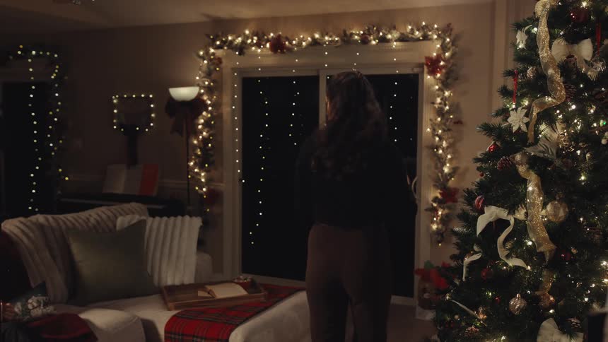 Two women smile and frown during interactions in a home decorated for christmas