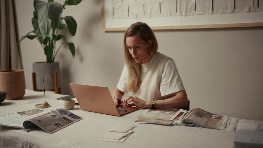 A woman sitting in a room using a laptop