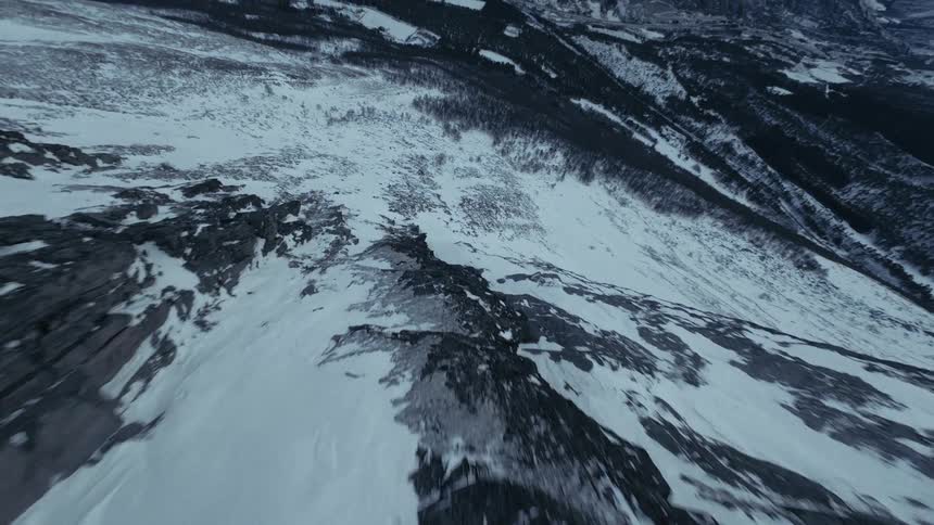An aerial view of a mountain range covered in snow