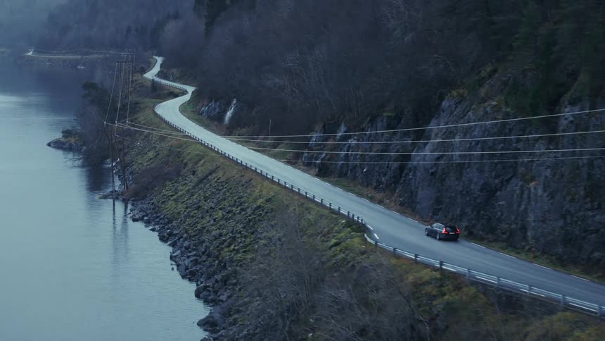 Car driving along winding riverside road