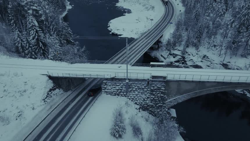 An aerial view of a car driving in a snowy day