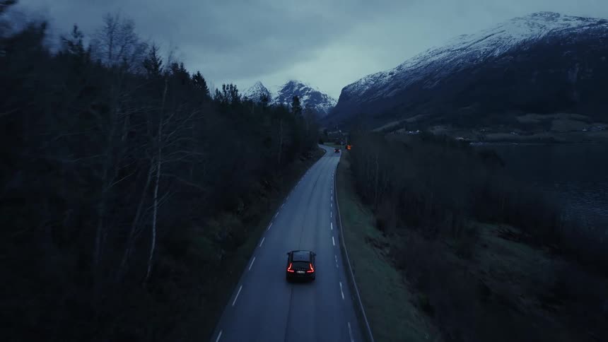 Car driving on mountain road at dusk