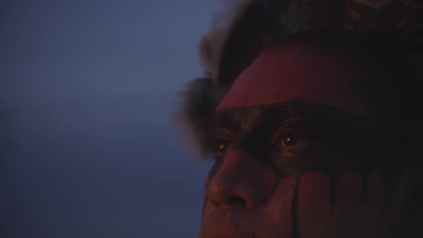 Face painted with black markings under red light