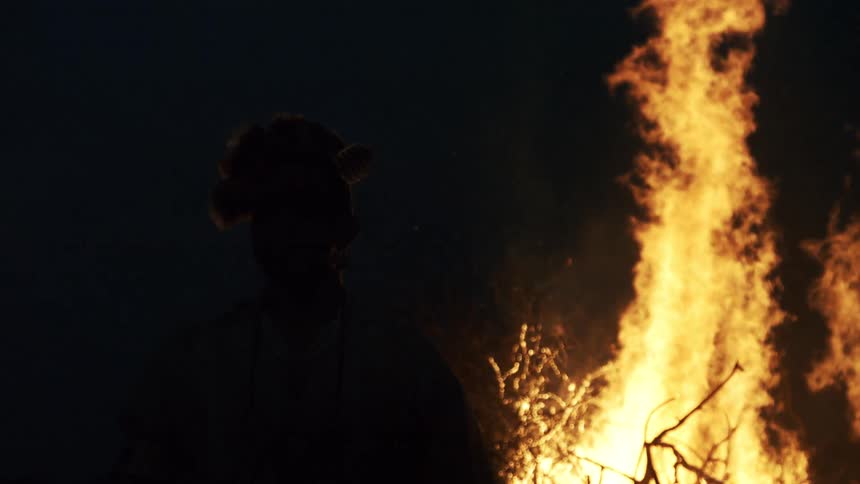 A fire burning outdoors at night