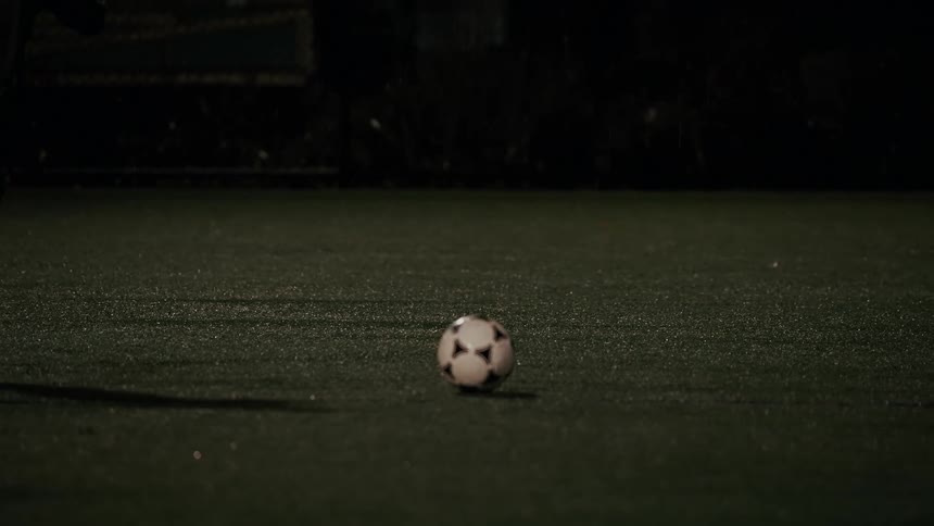A man kicking a soccer ball outdoors
