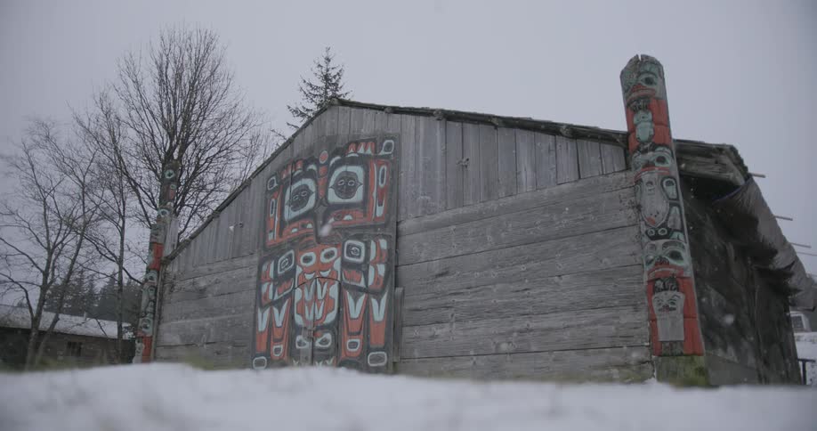 Building with native american artwork on the front as snow falls on the neighborhood