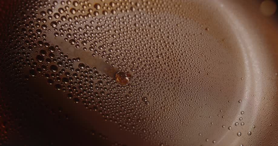 Condensation droplets cover a lit metallic surface