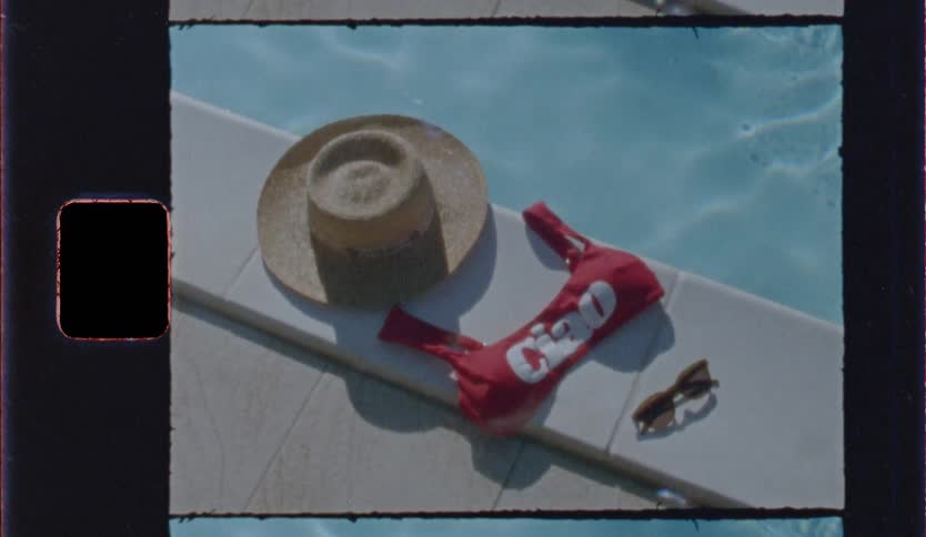 Hat red bikini with the word ciao and sunglasses are by the poolside