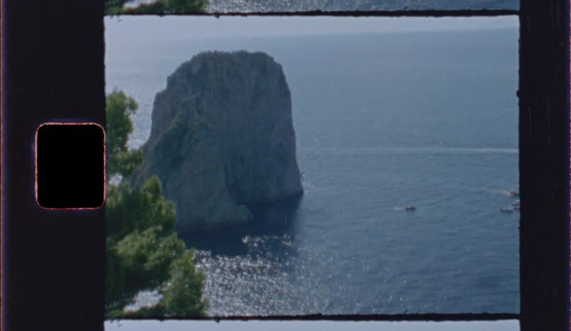 Isolated rocky island in blue sea seen from above