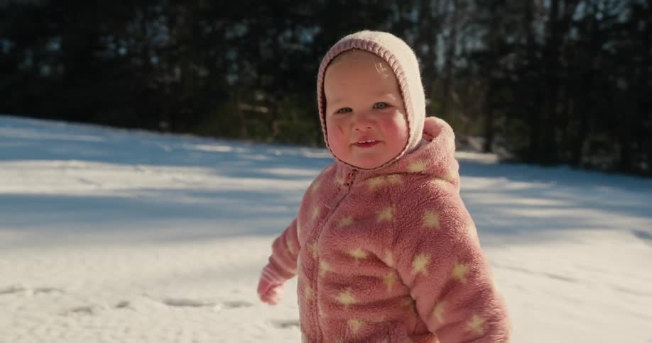 Little girl in a hat walking in the snow
