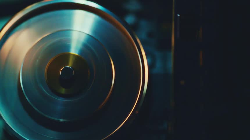 Metal disc spinning under bluegreen lighting in industrial equipment