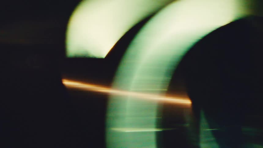 Blurred circular structures with a horizontal light streak in a dark setting